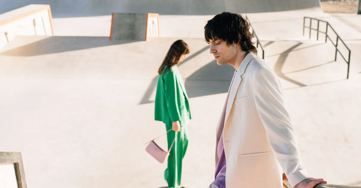 Personas a la moda en un entorno urbano moderno, con trajes blancos y verdes.