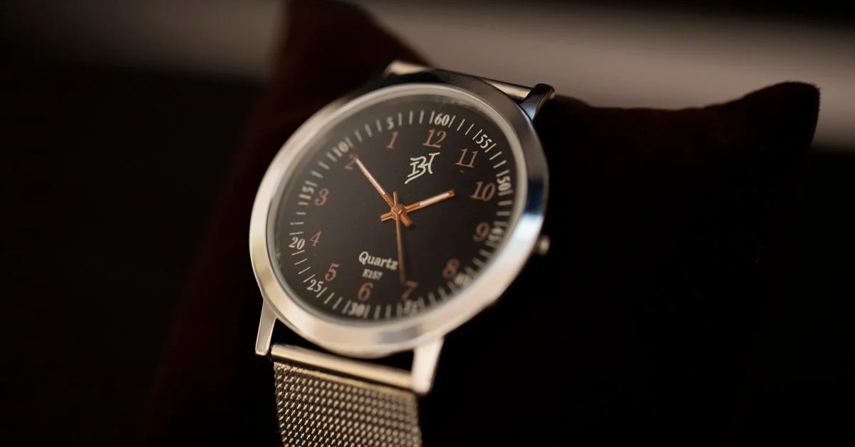 Primer plano de un elegante reloj de pulsera plateado con un diseño clásico, enfocándose en su cara y correa de metal.